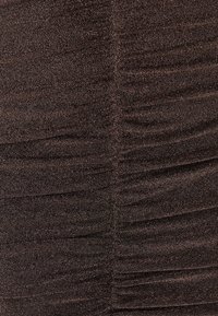 Hnedá textúrovaná tkanina s vráskavou vzorkou, obsahujúca jemné kovové nite pre zvýšený lesk a rozmer. Hladký povrch, stredná váha.