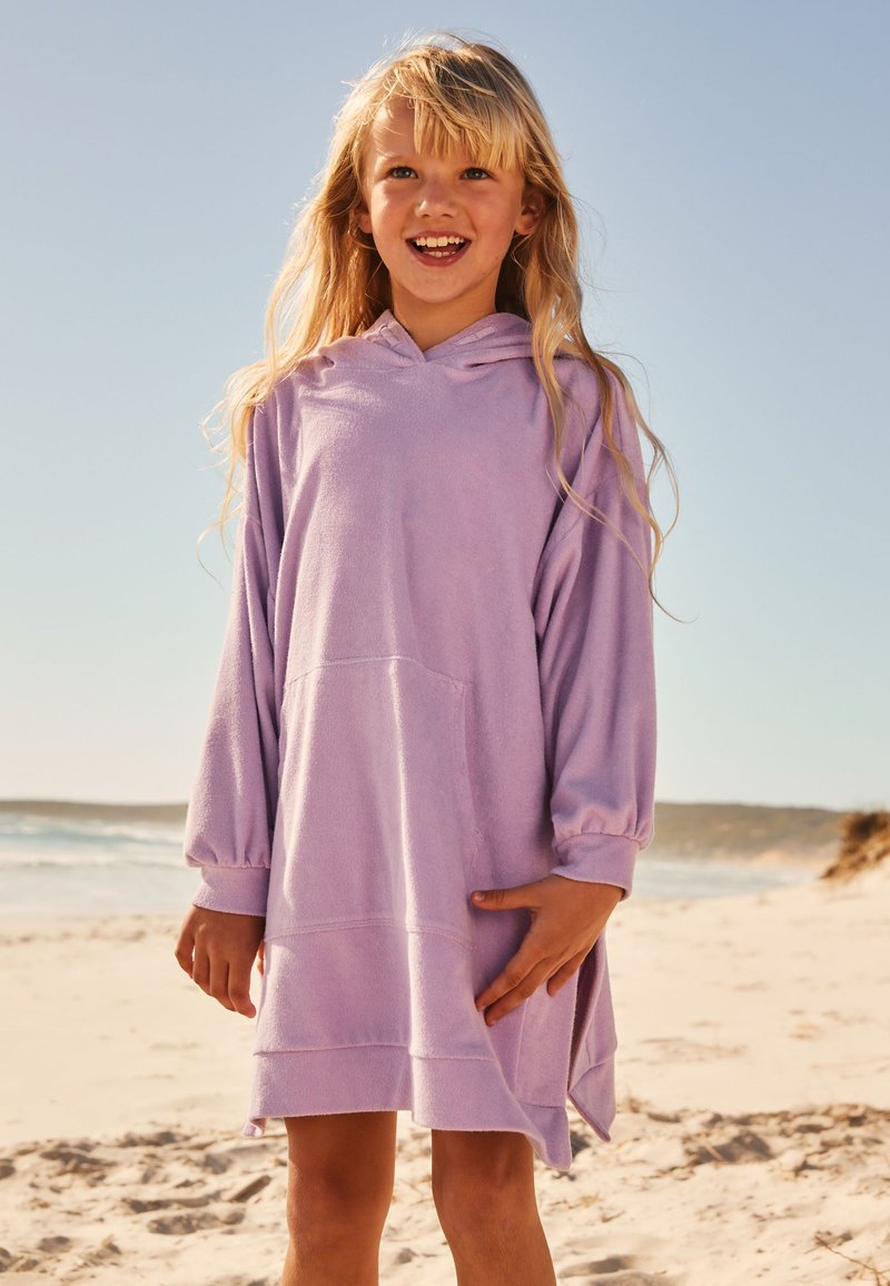 Light purple hooded beach cover-up dress with long sleeves, a kangaroo pocket, and a relaxed fit. Soft texture and rolled hems.