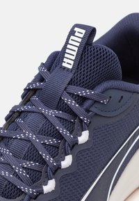 Navy mesh sneaker featuring white accents, textured surface, and distinctive PUMA branding on the tongue and side, with patterned laces.