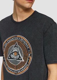 Zwarte graphic t-shirt met een cirkelontwerp met een oog binnenin een driehoek en tekst, gemaakt van zacht, textuurachtig stof.