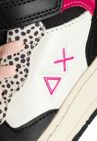 Sneaker con superiore sintetico nero, lato in pelle bianca con dettagli rosa e una texture maculata sull'overlay. Design geometrici notevoli.