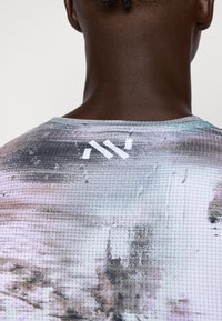 Kurze Ärmel Sportshirt mit einem strukturierten, abstrakten Muster in Grau- und Pastelltönen, mit einem weißen Logo auf dem Rücken.
