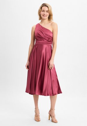 Ein ärmelloses, knielanges Kleid aus burgunderfarbenem Satin mit gerafftem Oberteil, tailliertem Bund und plissiertem Rock. Kombiniert mit sandaletten in Nude.