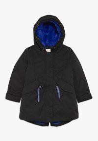 Svart parkad med huva, med ett blått foder i konstpäls, två framfickor och dragsko. Slätt yttermaterial med en modern passform.