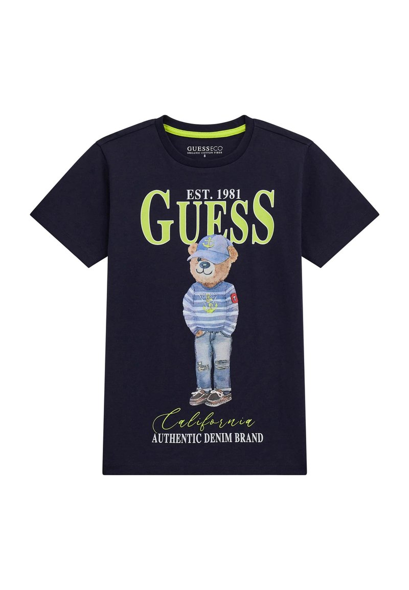 Una t-shirt in cotone blu navy presenta una grafica di un orso vestito con una maglietta a righe e un cappello, con il testo del marchio in verde acceso e la scritta "California" sotto.