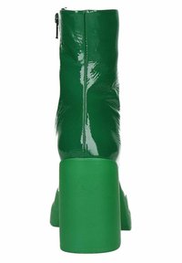 Botín de charol verde brillante hasta el tobillo con un chunky block heel y cierre de cremallera trasera, visto desde la parte trasera.
