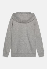 Ljusgrå hoodie med en stor huva, långa ärmar och ett mjukt strukturerat tyg. Enkel design utan yttre fickor eller utsmyckningar.