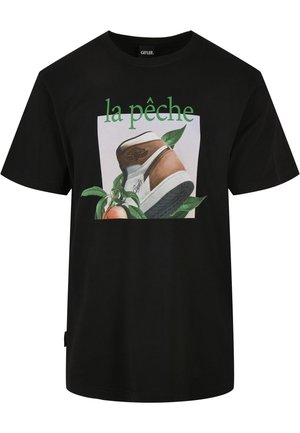 Czarna koszulka z grafiką brązowo-białego trampka, zielonych liści, brzoskwini oraz napisem „la pêche” w zielonym kolorze nad nimi.