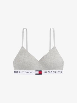 Grå bomullsbralette med V-halsdesign, tynne hvite stropper og et merket elastisk bånd i røde, hvite og blå farger.