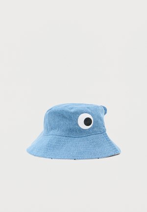Chapeau bob en denim bleu orné d'un motif d'œil ludique sur le côté, avec un large bord et un tissu texturé.