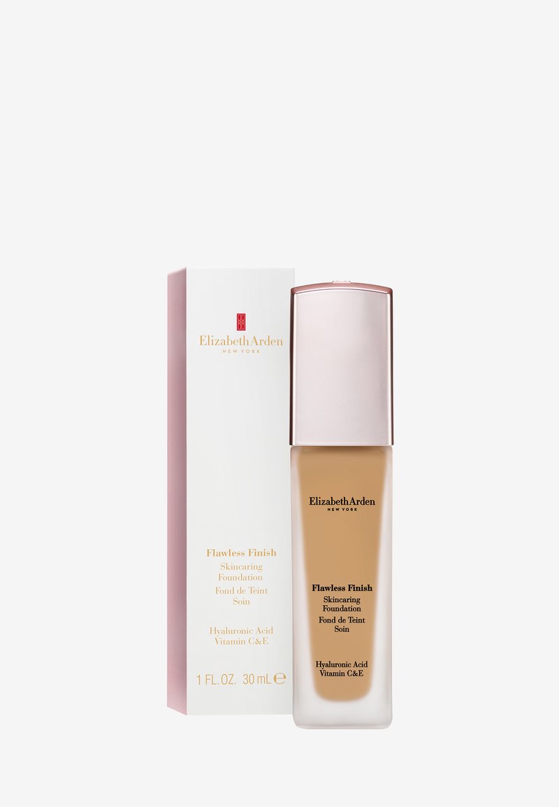 Flacon et boîte de Elizabeth Arden Flawless Finish Skincaring Foundation, fond de teint liquide beige avec acide hyaluronique et vitamines C et E.