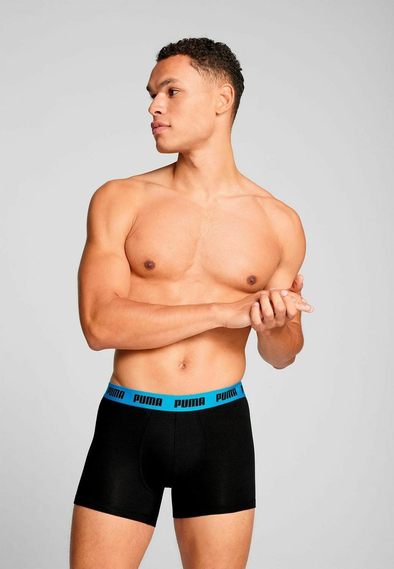 Black boxers with a blue Puma logo on the waistband. The design features a fitted shape and soft, athletic fabric.