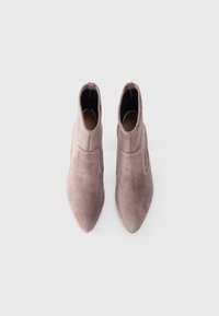 Pointed-toe ankle boots in soft mauve suede, featuring a fitted silhouette and no visible hardware. Smooth texture with a minimalist design.