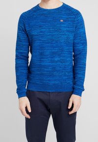 Blauer Strickpullover mit strukturiertem Muster, rundem Ausschnitt und gerippten Bündchen und Saum. Kleines Logotag auf der Brust.