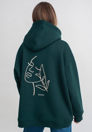 Groene hoodie met een minimalistische lijntekening van een gezicht en bladeren op de achterkant, gemaakt van zachte stof met geribbelde manchetten.