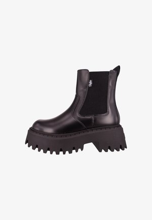 Černá kotníková bota vyrobená z lesklého syntetického materiálu, s elastickými postranními panely, robustními zubatými podešvemi a poutkem na zadní straně.