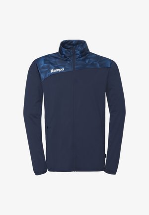 Marineblauw zip-up jack met hoge kraag, geometrisch patroon op de achterkant en het "Kempa"-logo op de linkerborst.