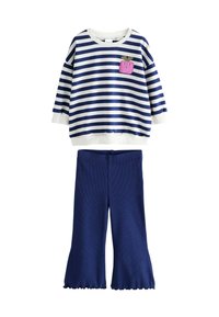 Kinderoutfit mit einem navy-weiß gestreiften Langarmoberteil, das mit einem pinken Obst-Patch verziert ist, kombiniert mit einfarbigen navyblauen Schlaghosen.