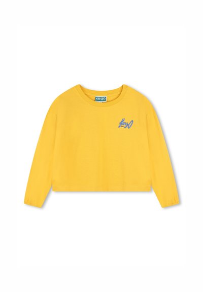 T-shirt jaune à manches longues cropped fabriqué en coton doux. Présente des poignets froncés et un logo brodé bleu à l'avant.