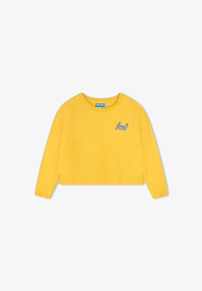 T-shirt jaune à manches longues cropped fabriqué en coton doux. Présente des poignets froncés et un logo brodé bleu à l'avant.