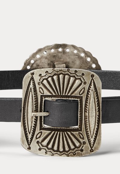 Musta nahkavyö, jossa on antiikkisilveristä valmistettu suorakaiteen muotoinen solki, jossa on kaiverrettuja geometrisia ja viuhkamaisia kuvioita.