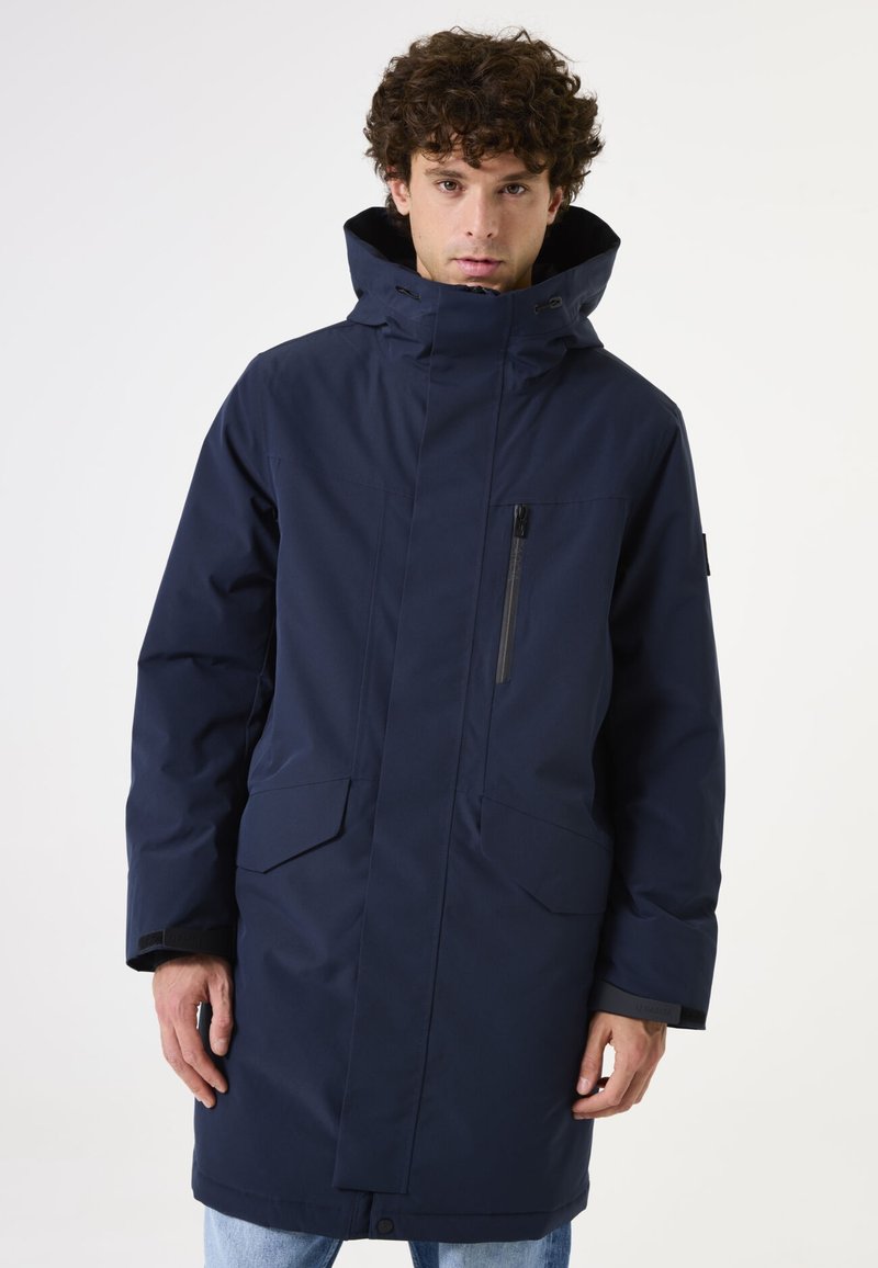 Parka larga de color azul marino con un alto cuello, cremallera frontal, bolsillo en el pecho y dos bolsillos laterales, fabricada con tejido resistente al agua.