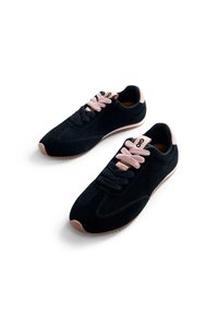 Chaussures de sport en maille noire et en daim avec des lacets roses, bout arrondi et semelle en caoutchouc brun clair. Présente une étiquette de logo au niveau du talon.