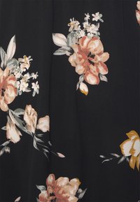 Schwarzer Stoff mit großem Blumenmuster in Pfirsich-, Creme- und Gelbtönen, ergänzt durch grüne Blätter und Akzente. Weiche Textur.