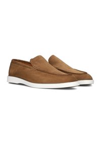 Chaussures en suède marron à enfiler avec une semelle en caoutchouc blanc, présentant un devant lisse et un discret détail de couture le long du bord.