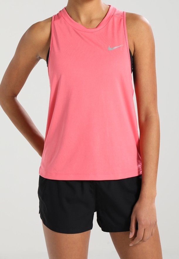 Canotta atletica senza maniche di colore rosa con scollatura rotonda, caratterizzata da un piccolo logo Nike in argento. Indossata con pantaloni sportivi neri, in tessuto liscio.