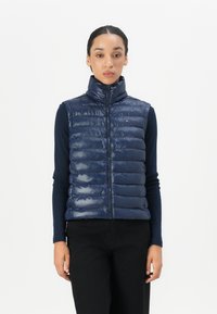 Navy puffer vest with high collar, glossy finish, quilted design, front zipper closure, featuring a small logo on the chest.