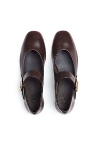 Braune Leder-Mary-Jane-Schuhe mit einer abgerundeten Spitze, einem Knöchelriemen und goldfarbenen Schnallendetails. Glatte Oberfläche mit minimalistischer Gestaltung.
