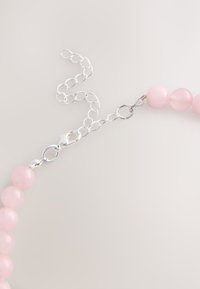 Pink bead necklace with smooth round beads and a silver metal chain and clasp, featuring a lobster clasp fastening and extender links.