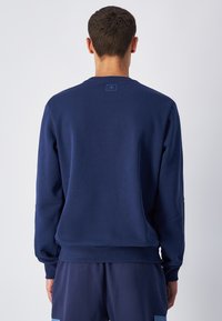 Felpa blu navy con maniche lunghe, polsini a coste e scollo rotondo. Presenta un piccolo etichetta con logo sul retro. Tessuto in cotone liscio.