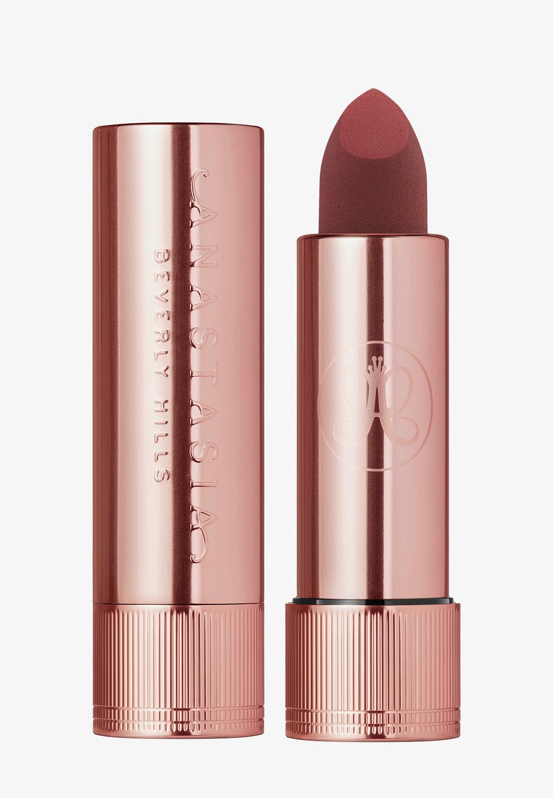 Roze gouden lippenstiftbuis met een afgeronde punt. Gegraveerde merknaam en logo op het oppervlak. Matte lippenstift zichtbaar, rechtop weergegeven.