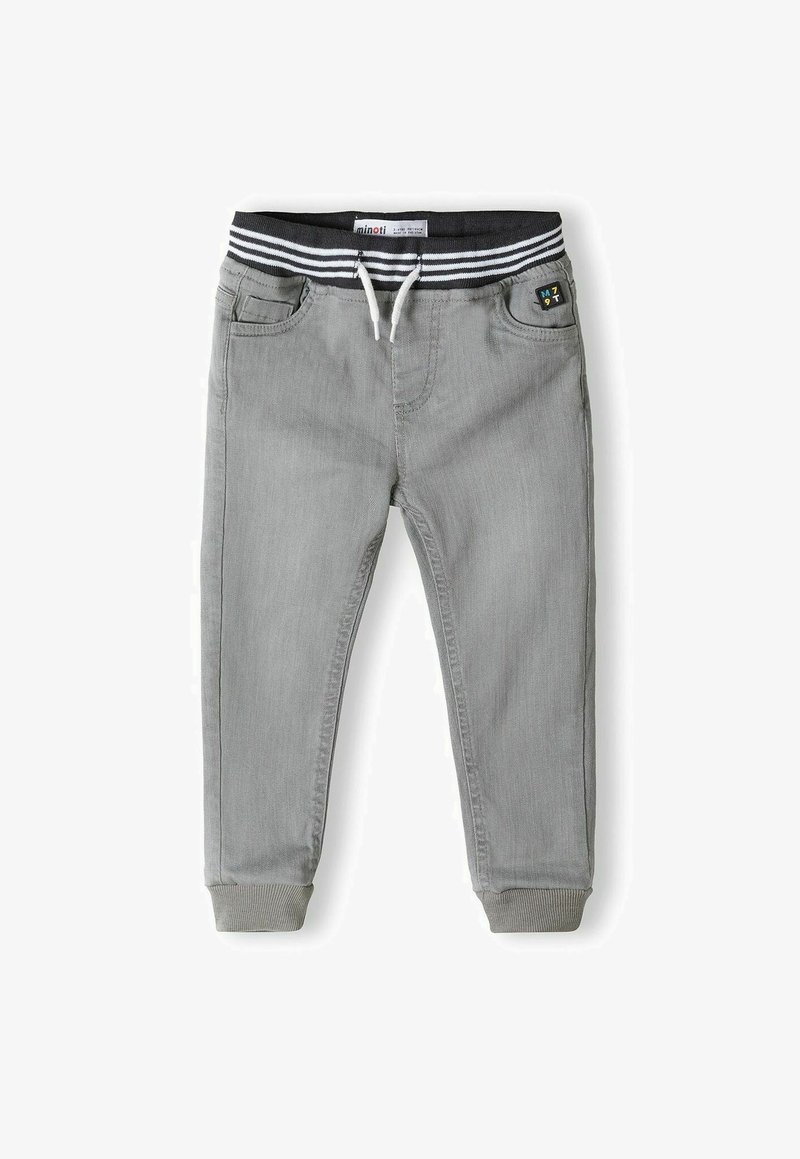 Pantalons de jogging gris avec une taille élastique à rayures noires et blanches, cordon de serrage et poignets côtelés, dotés de poches avant et d'un détail en patch.