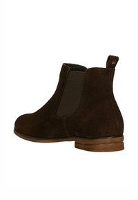 Brązowy zamszowy botek Chelsea z elastycznym panelem bocznym, pętelką na pięcie i piętą z warstwowanego drewna, pokazany od zewnętrznej strony.