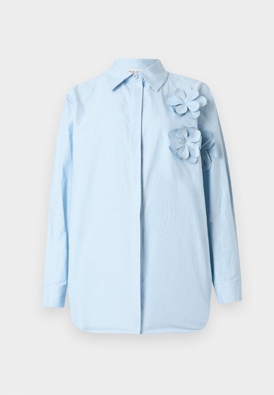 Light blue shirt with long sleeves, button-down collar, and three fabric flowers on the left side. Soft, smooth texture.