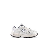 Chaussure de sport New Balance blanche et grise avec des panneaux en mesh, des lacets et une semelle texturée, vue de profil sur fond blanc.