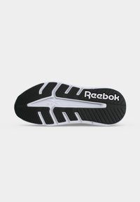 Μαύρη και λευκή σόλα παπουτσιού Reebok με υφή και σχέδια για καλύτερο κράτημα και το λογότυπο Reebok στην περιοχή της φτέρνας.