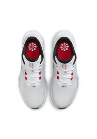 Pantofi de golf albi cu un superior texturat, margine neagră în jurul gleznei, șirete albe și accente roșii pe limbă și branț.