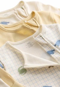 Tre babybodies i mjuk bomull, i färgerna gul, krämig och med ett rutmönster i blå och gröna djurtryck. Tryckknappar vid halsen.