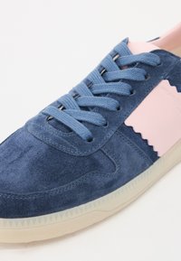 Plave suede tenisice s ružičastim naglascima, okrugli vrh, ravni gumeni potplat i plave vezice. Sadrži teksturirane detalje i kontrastne boje.