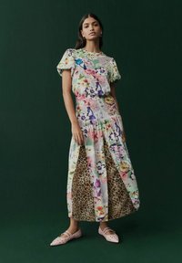 Abito maxi con design floreale e dettagli in stampa leopardata, maniche corte a palloncino, vita elastica e tessuto fluido. Abbinato a ballerine rosa con borchie.