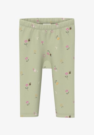 Hellgrüne Leggings mit einem bunten Muster aus Blumen und Bienen, das über den Stoff verteilt ist.