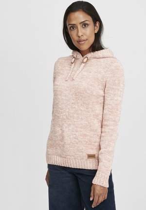 Pink knitted sweater with a hood, featuring round drawstrings, ribbed cuffs, and a small label on the bottom left. Textured fabric.