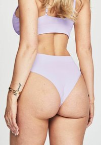 Ensemble de bikini lilas à côtes comprenant un bralette avec des bretelles ajustables et un bas taille haute. Texture douce avec des détails matériels minimalistes.