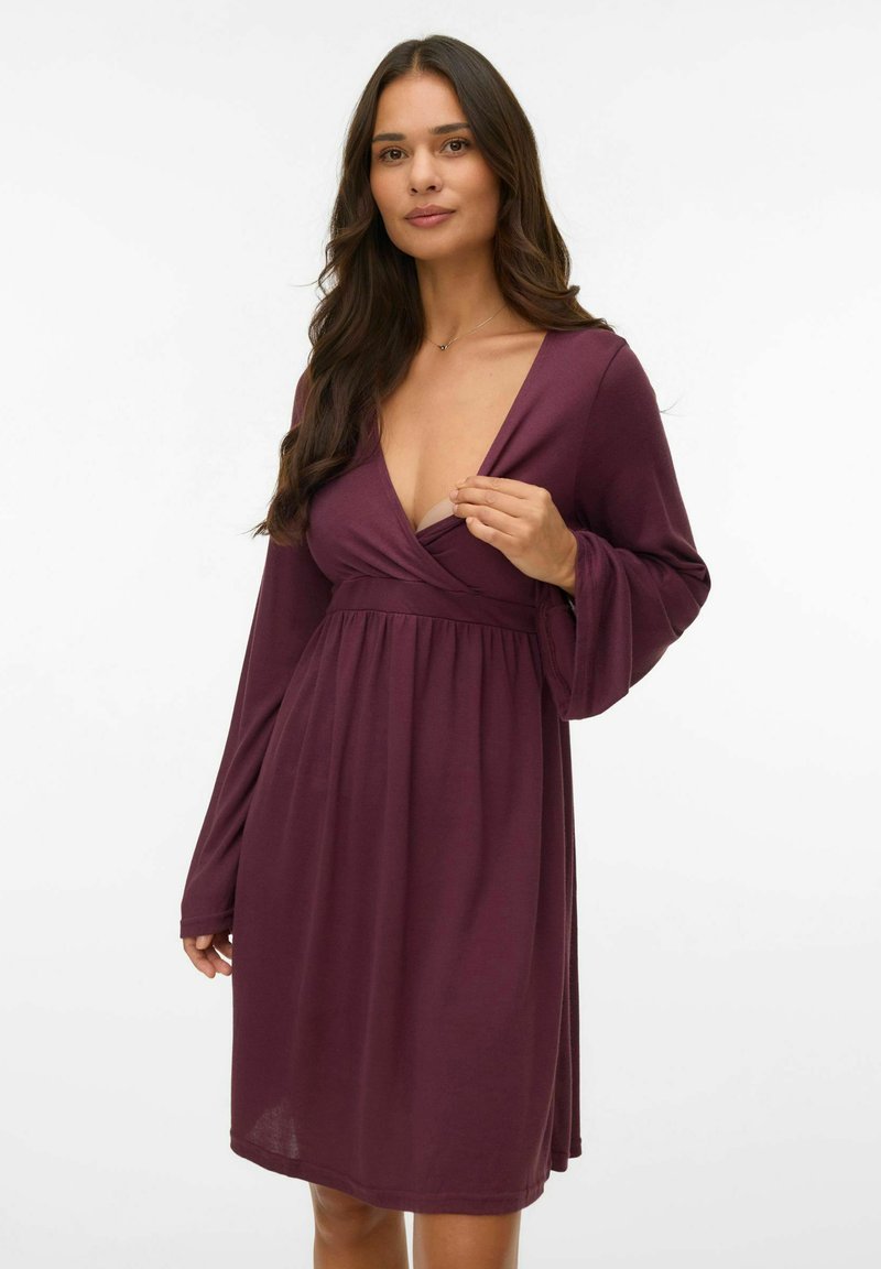 Slivova kratka obleka z dolgimi zvončastimi rokavi, globokim V-izrezom in empire pasom. Mehka tkanina z lepršavim krilom in subtilnim drapiranjem.