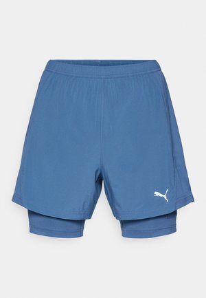 Puma blaue Sportshorts mit einem geschichteten Design, elastischem Bund, glatter Textur und einem weißen Logo am unteren Bein.