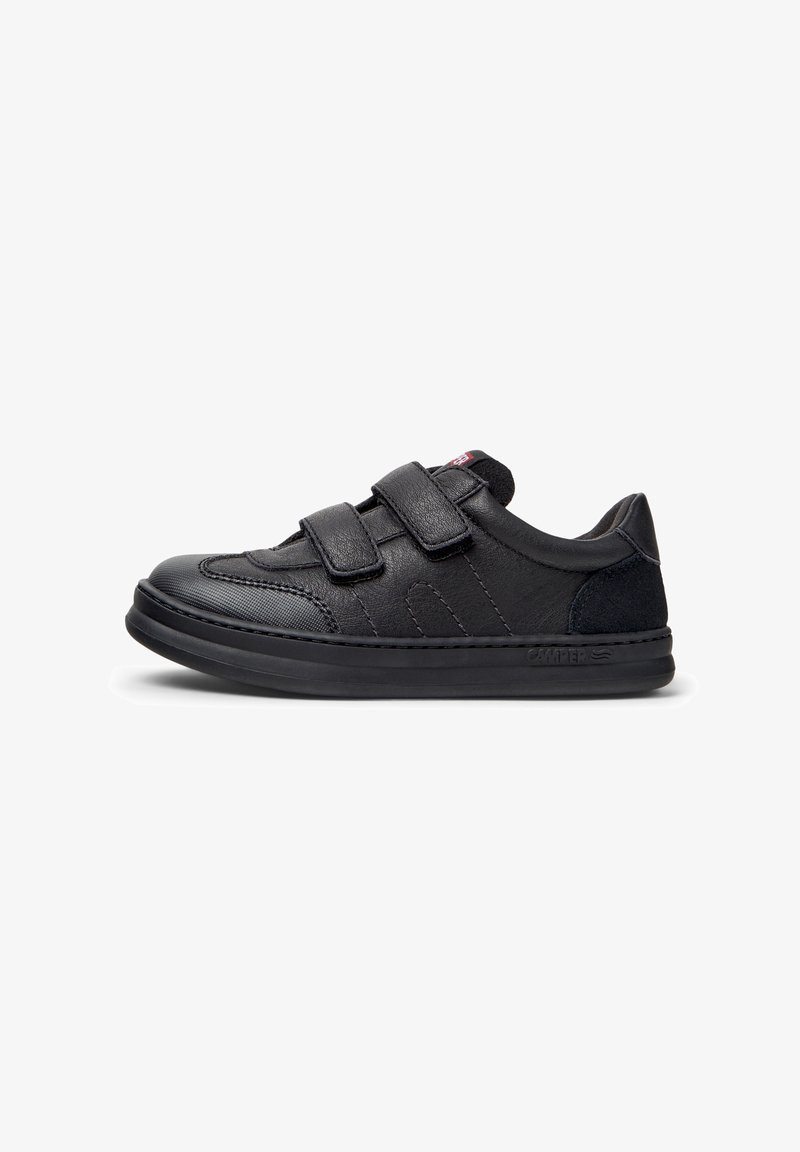 Sneaker nera con due cinturini in velcro, realizzata in pelle e suede, caratterizzata da una punta arrotondata e una suola in gomma testurizzata. Elementi di design minimalisti.